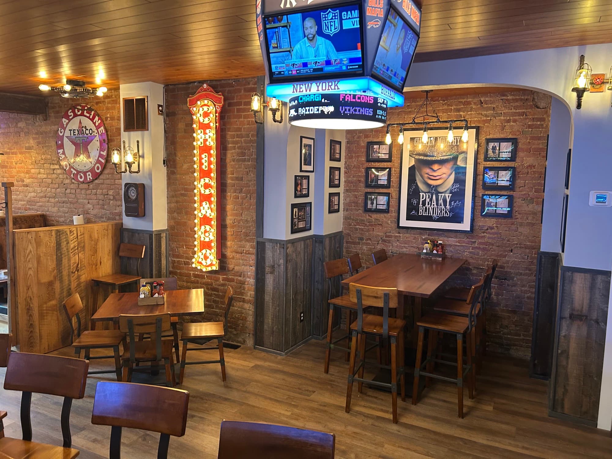 Rustic brick interior with wooden tables, NFL game screens, and vintage Texas decor
